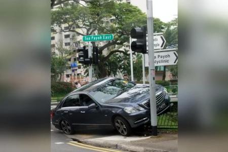 Driver taken to hospital after car skids into traffic light pole