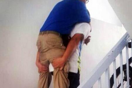 Lift out of order: Town council staff carry resident, who had problems walking, up 10 floors