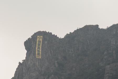 Hong Kong climbers hang protest banner off landmark cliff