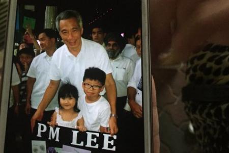 A six-year-old's placard catches PM Lee's attention at Ang Mo Kio GRC's Tribute Night