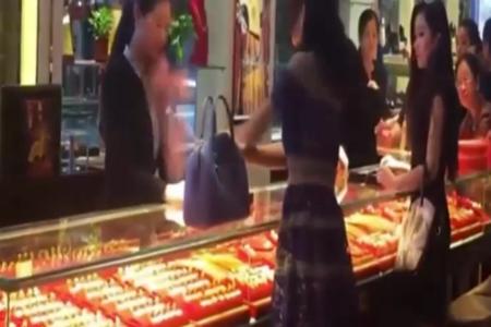 Woman throws yuan bills at saleswoman's face