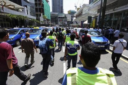 Malaysian cabbies block roads in protest over GrabCar promotion