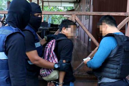 Special Branch Counter Terrorism Division personnel arrest a 24-year-old resort worker in Kota Tinggi.