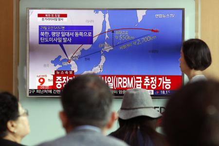 South Koreans watch a television displaying news broadcasts reporting on North Korea&#039;s latest ballistic missile launch,