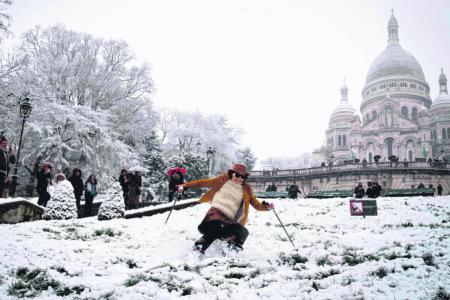 Skiers take to Paris streets as snow prompts travel chaos