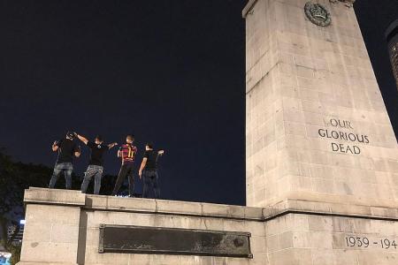 Photo of four young men standing on war memorial draws flak