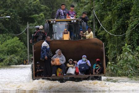 Malaysian villagers evacuated in excavator as floods hit