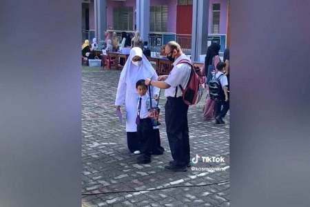 Malaysian parents wear school uniforms as they take son to school on his first day
