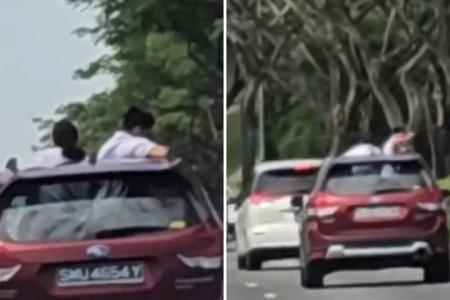 2 students stand in moving car through moonroof on KPE