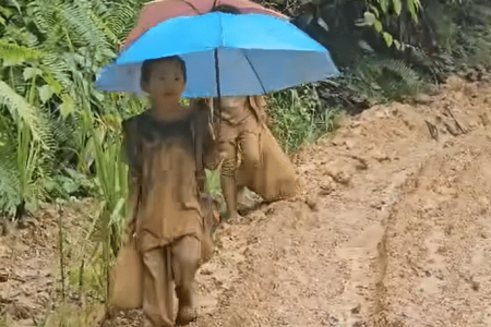 Sabah pupils, teachers walk for two days on rain-soaked mud track to get to school
