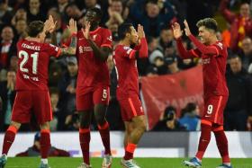 Roberto Firmino (right) celebrates with teammates after scoring for Liverpool.