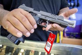 A worker holds a pistol at a gun store in Florida.