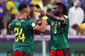 Cameroonian players Enzo Ebosse (left) and Andre-Frank Zambo Anguissa celebrate beating Brazil, despite not going through.