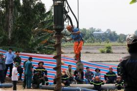 Rescuers gather at the site where a 10-year-old boy is stuck in a 35-meter deep hole in Dong Thap Province, Vietnam, on Jan 2, 2023. 