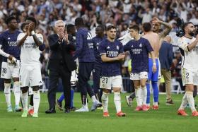 Players of Real Madrid and head coach Carlo Ancelotti applaud supporters as they celebrate winning the Spanish La Liga match against Cadiz and the title.