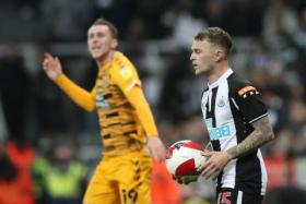 Cambridge United's Adam May celebrates as Newcastle United's Kieran Trippier looks dejected after the match.
