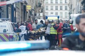 First responders move a man on a gurney after gunshots were fired in central Paris, France, on Dec 23, 2022.