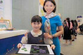 Raffles Girls’ Primary School pupil Abbie Milner with her mother and the 3D board game she created.
