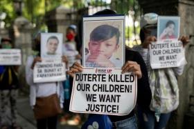 FILE PHOTO: Relatives of drug war victims hold photographs of their slain loved ones with placards calling for justice, during a protest to commemorate President Rodrigo Duterte's final year in office, in Manila, Philippines, June 30, 2021. REUTERS/Eloisa Lopez/File Photo