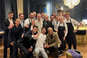Barack Obama, Steven Spielberg and Bruce Springsteen pose for a photo with staff of the Amar restaurant in Barcelona.