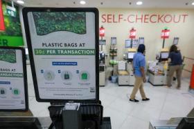 A customer packing groceries at the FairPrice Xtra outlet in Kallang Wave Mall – one of 11 FairPrice supermarkets charging 20 cents per transaction for plastic bags.