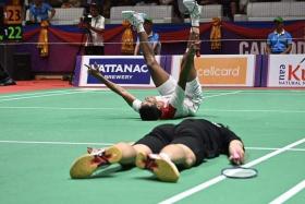 Singapore’s Loh Kean Yew (in black) is floored as Indonesia’s Dwi Wardoyo celebrates after winning a closely match in the SEA Games men&#039;s team semi-finals.
