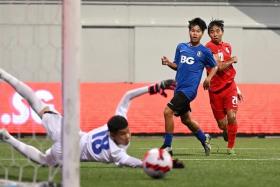 Singapore U-15&#039;s Nathan Mao (in red) watches as he goes close to scoring in the Lion City Cup final against BG Pathum.