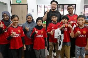 Mr Kiat Lim (in black) with the eight children and youth going to Manchester.