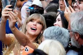 A 2022 photo shows singer Taylor Swift posing for a selfie with fans at the Toronto International Film Festival in Canada.