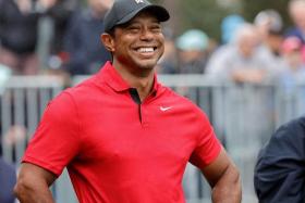Tiger Woods smiling before he plays his shot from the first tee during the PNC Championship at The Ritz-Carlton Golf Club. 