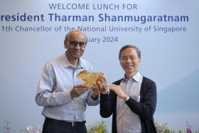 President Tharman Shanmugaratnam (left) presented with a memento called “Elements of the NUS Crest” by the NUS board chairman Hsieh Fu Hua on Jan 4.