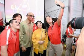 President Tharman Shanmugaratnam and Mrs Jane Ittogi Shanmugaratnam pose for a wefie with swimmers (from left) Maximillian Ang, Zackery Tay, Ritchie Oh (partially hidden) and Quah Ting Wen at the Team Singapore reception. 