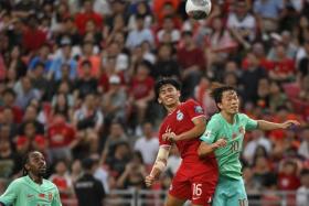 Singapore&#039;s Glenn Kweh (in red) tussling with China&#039;s Xie Pengfei during a World Cup qualifier at the National Stadium on March 21.