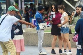 Photographers approaching tourists around the Kuala Lumpur City Centre area.
