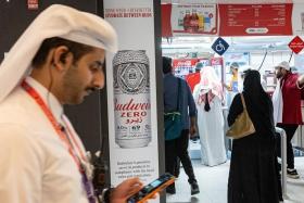 A Budweiser Zero beer advertisement is pictured as customers wait at a food stand during the World Cup opening game between Qatar and Ecuador at the Al Bayt Stadium in Al Khor on Sunday.