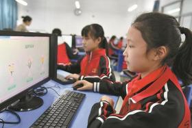 Students pay respect to the deceased through a website at their school in Zigui, Hubei province.