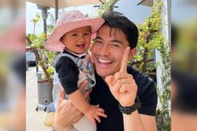 Henry Golding and Lyla are pictured all smiles, with the latter proudly showing off four cute baby teeth.