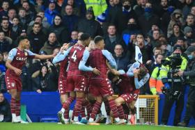 Aston Villa's Matty Cash (right) and Lucas Digne (second right) react after being struck by a bottle thrown from the crowd during their goal celebrations in a match against Everton.