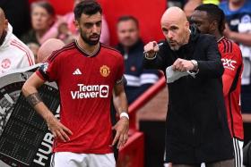 Manchester United manager Erik ten Hag speaking to captain Bruno Fernandes during the 3-1 Premier League defeat by Brighton on Sept 16.