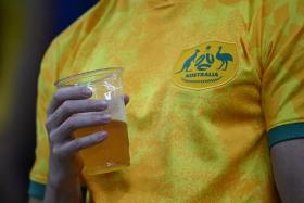 An Australia suporter holds a non-alcoholic beer as he waits for the start of the World Cup Group D match.
