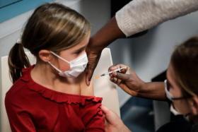 A child receives a dose of the Pfizer/BioNTech vaccine against Covid-19, in Paris, on Dec 17, 2021.
