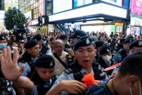 Police arresting performance artist Sanmu Chen (centre) in Causeway Bay near Victoria Park in Hong Kong on June 3, a day before the anniversary of the 1989 Tiananmen Square crackdown.