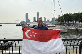 Dr Chua Jia Long holding the Singapore flag after completing the 8 Bridges Hudson River Swim on Friday. 