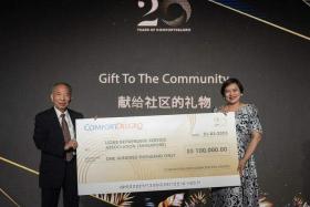 ComfortDelGro chairman Lim Jit Poh (left) presents Ms Karen Wee with a $100,000 cheque for Lions Befrienders.