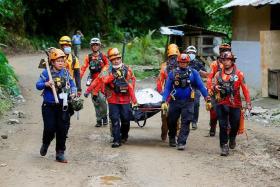 Rescuers carry a body bag as search and rescue operations continue in the landslide-hit village of Masara, Maco, Davao de Oro, Philippines, February 8, 2024. REUTERS/Mark Navales/ File photo