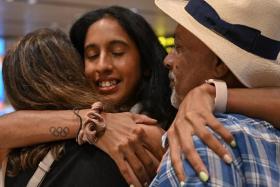 Shanti Pereira hugging her parents Clarence and Jeet Pereira after arriving at Changi Airport on Friday.