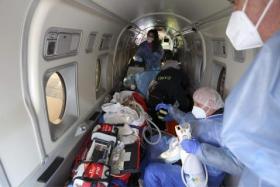 Paramedics, nurses and doctors tend to a Covid-19 patient aboard a medical aircraft en route from the French Mediterranean island of Corsica to Brest, in western France, on Jan 5, 2022.