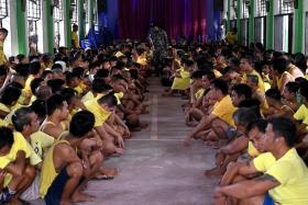 Prison inmates in a compound chapel as police conduct a drug search operation in the cells in Manila on Oct 21, 2022.