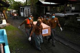 Prison inmates carry a coffin during a mass burial of 70 unclaimed bodies of prisoners at New Bilibid Prison Cemetery in Muntinlupa, metro Manila on Dec 2, 2022. 