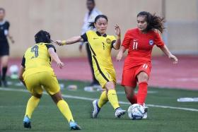 Singapore&#039;s Nur Putri Syaliza (right) attempting to get past Malaysia&#039;s defenders during the AFF Women&#039;s Championship on July 4, 2022. 